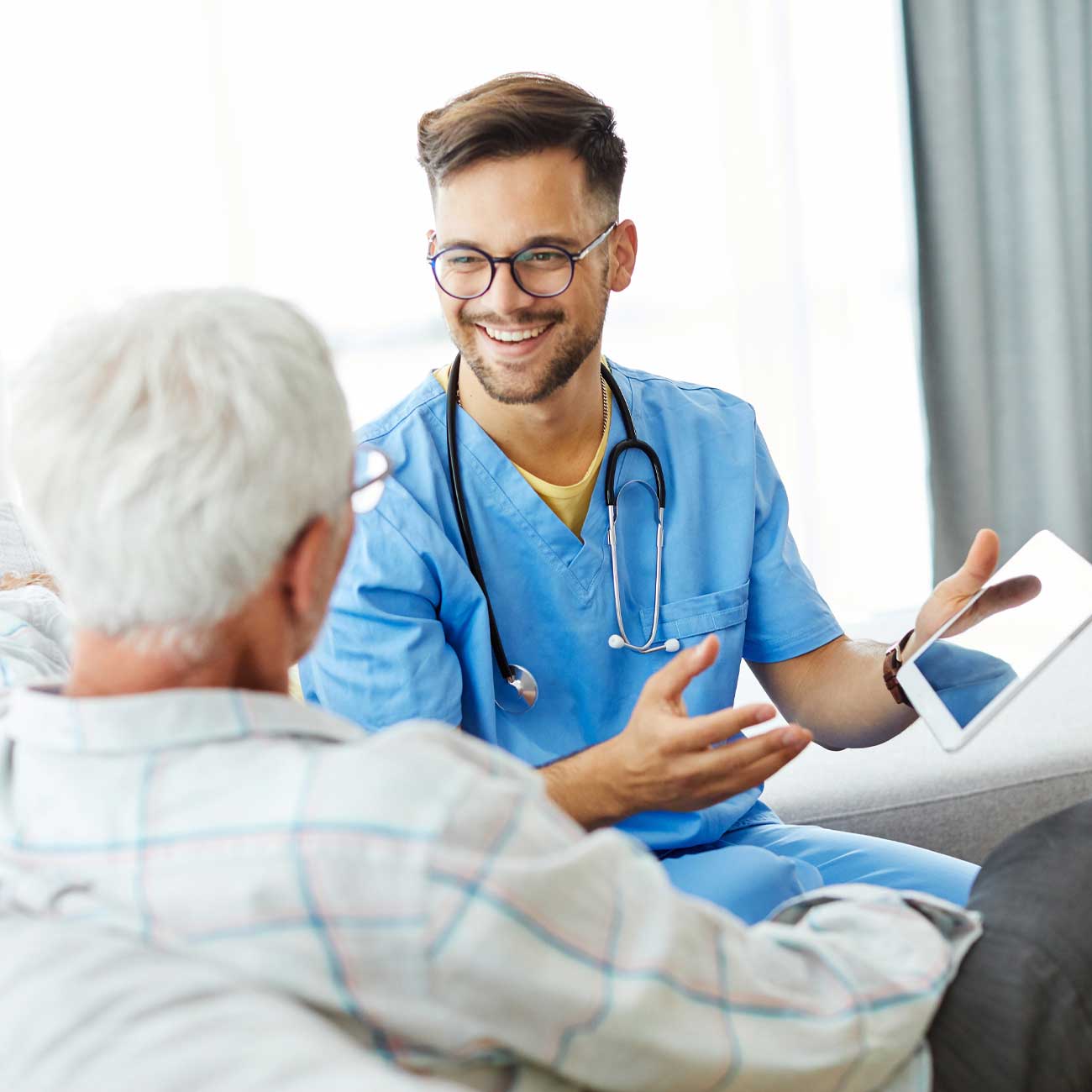 Nurse with tablet talking to patient
